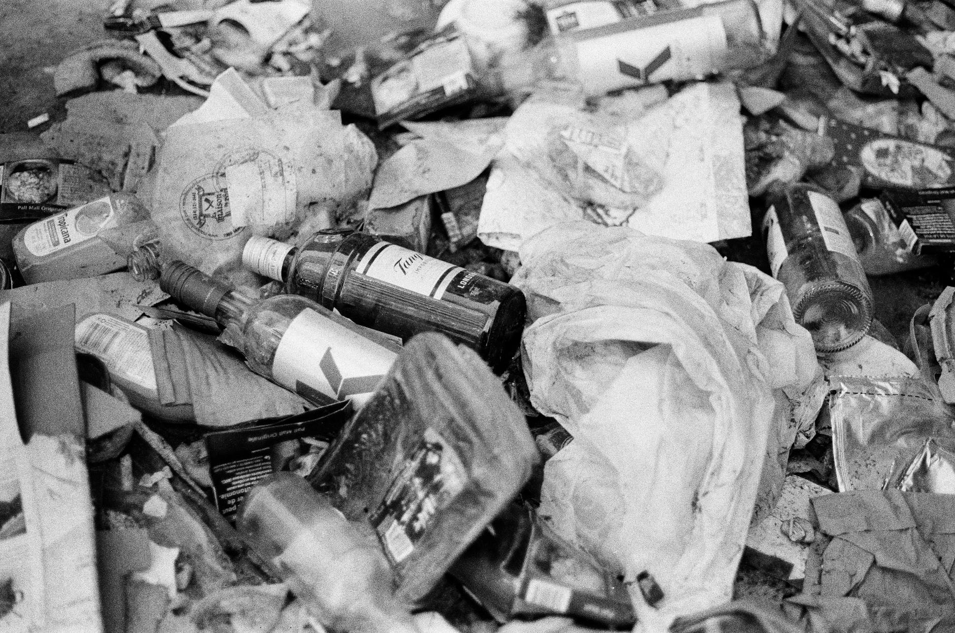 a grayscale photo of empty bottles and trash