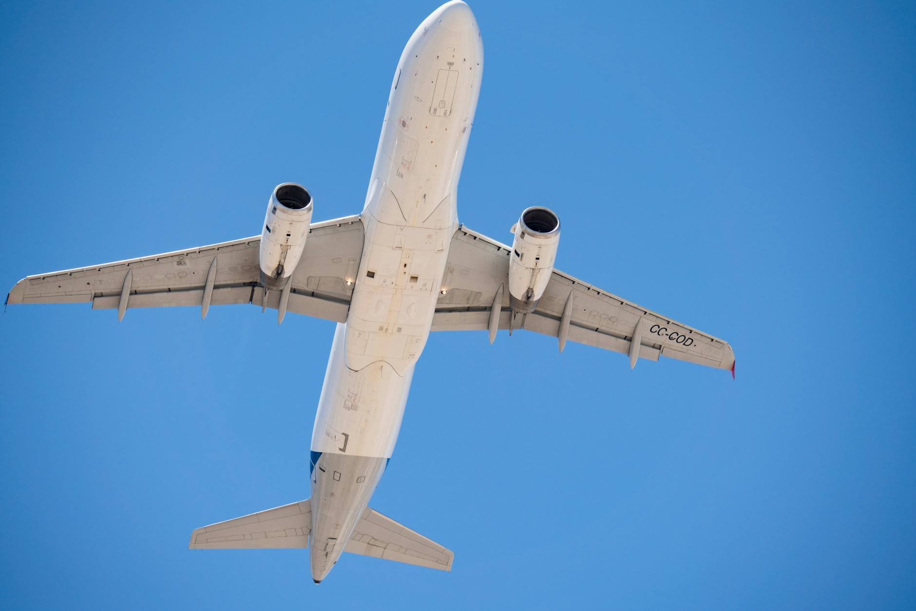 commercial airplane flying overhead in blue sky