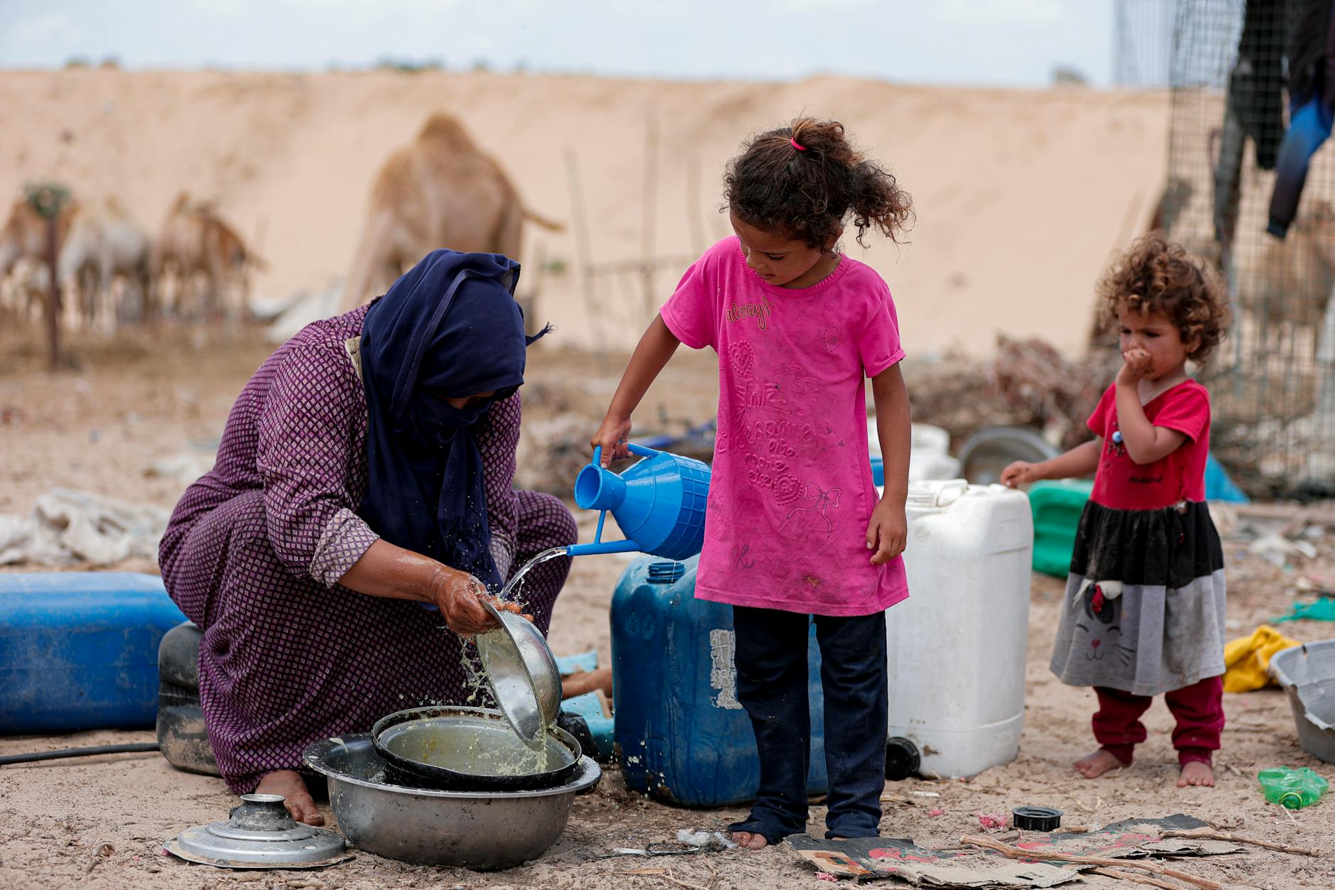family collecting water in gaza desert