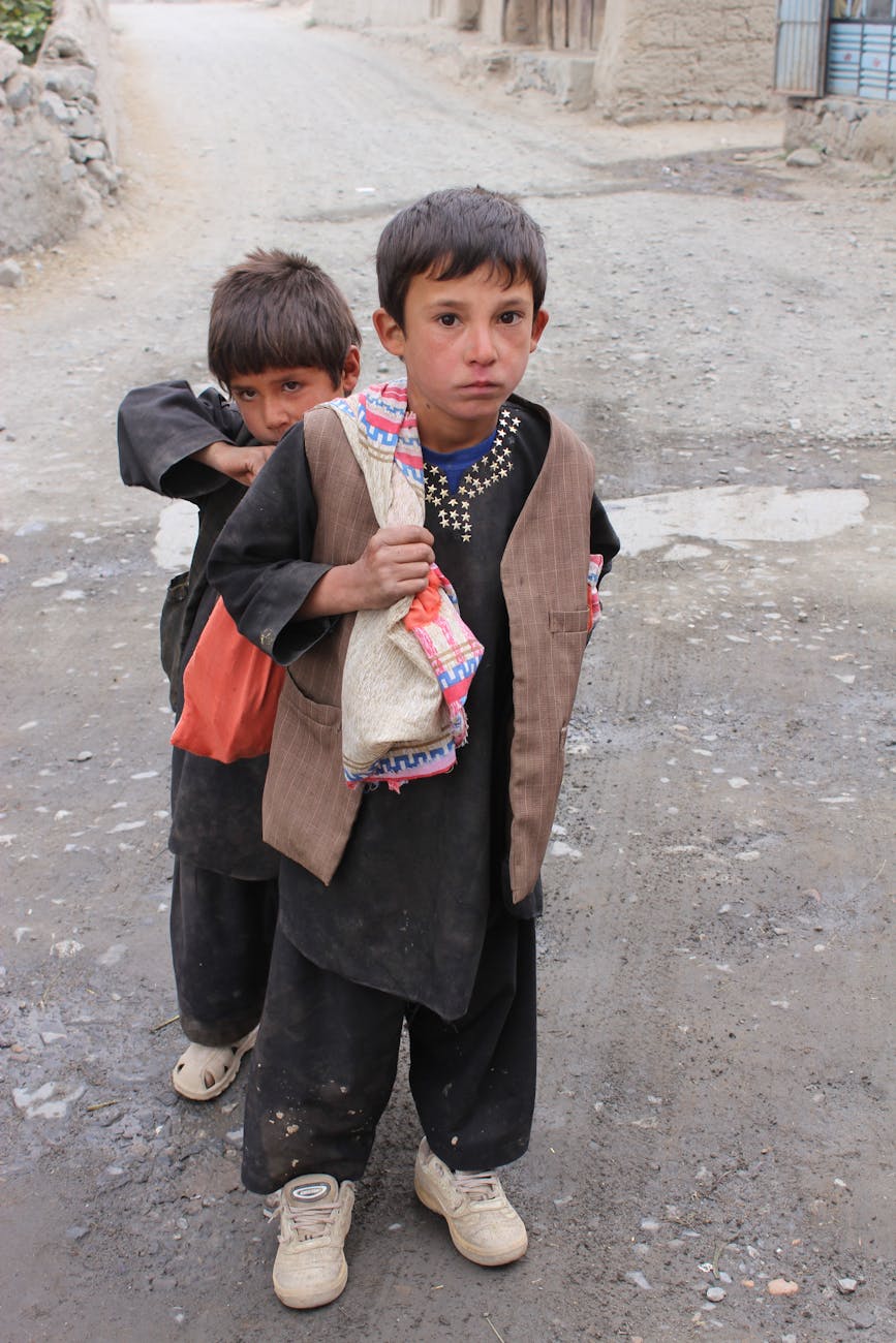 poor small boys on city street