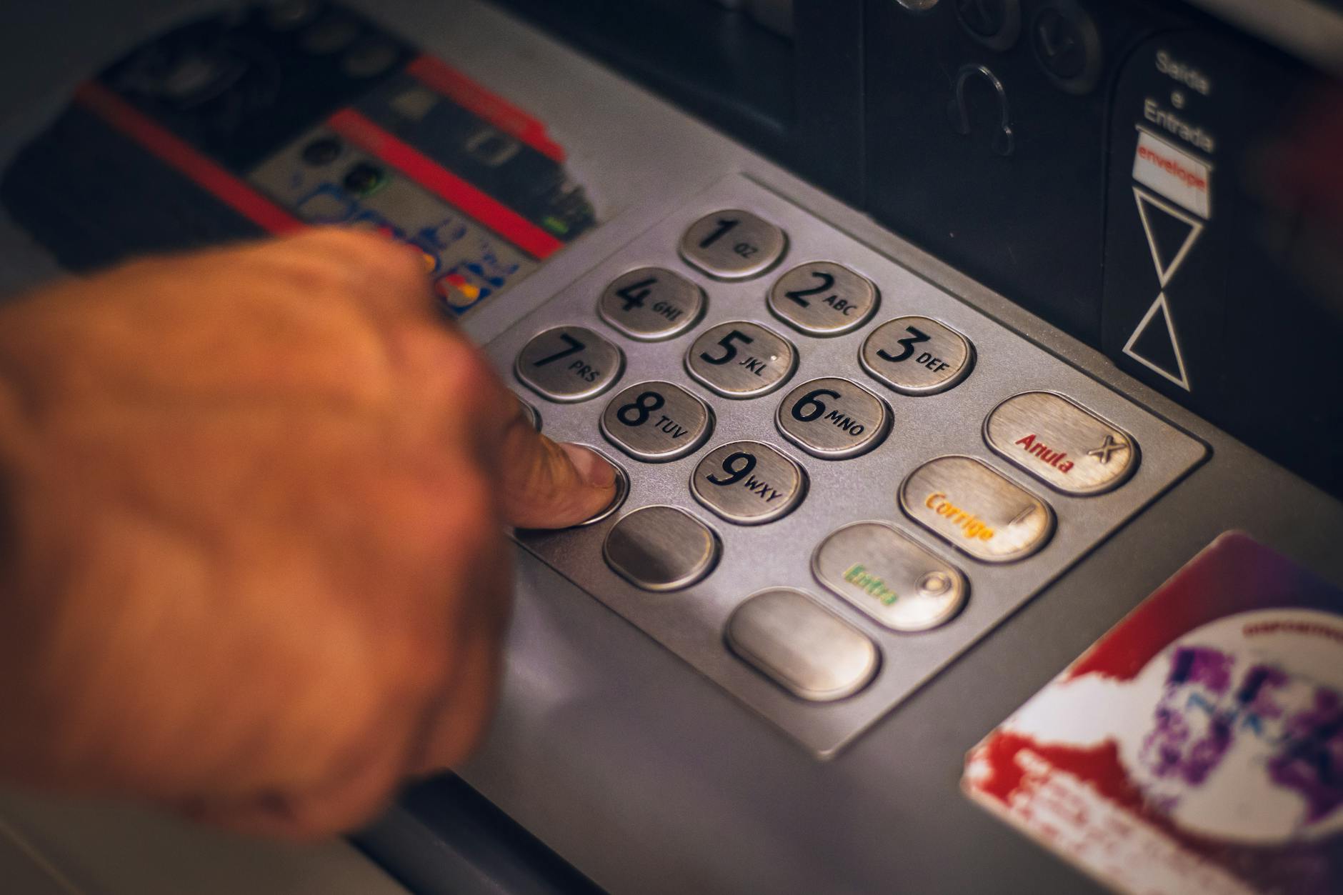 person pressing keys of an atm