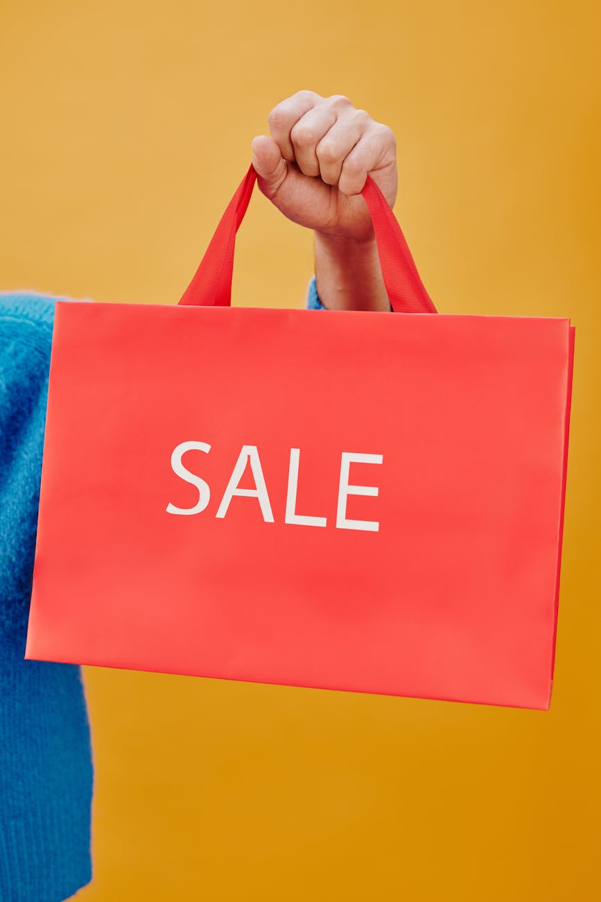 person holding a red paper bag