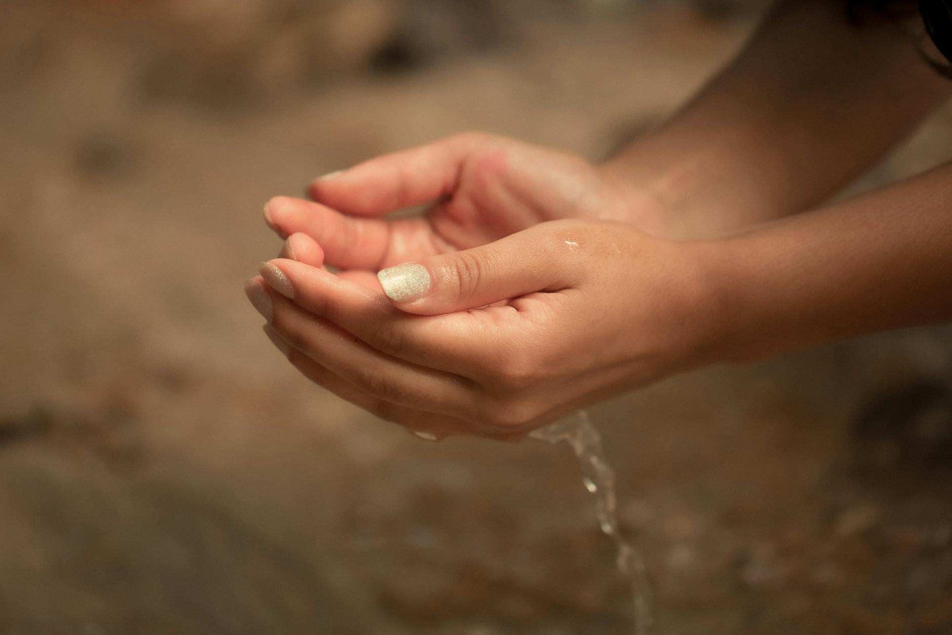woman with water in hands in forest