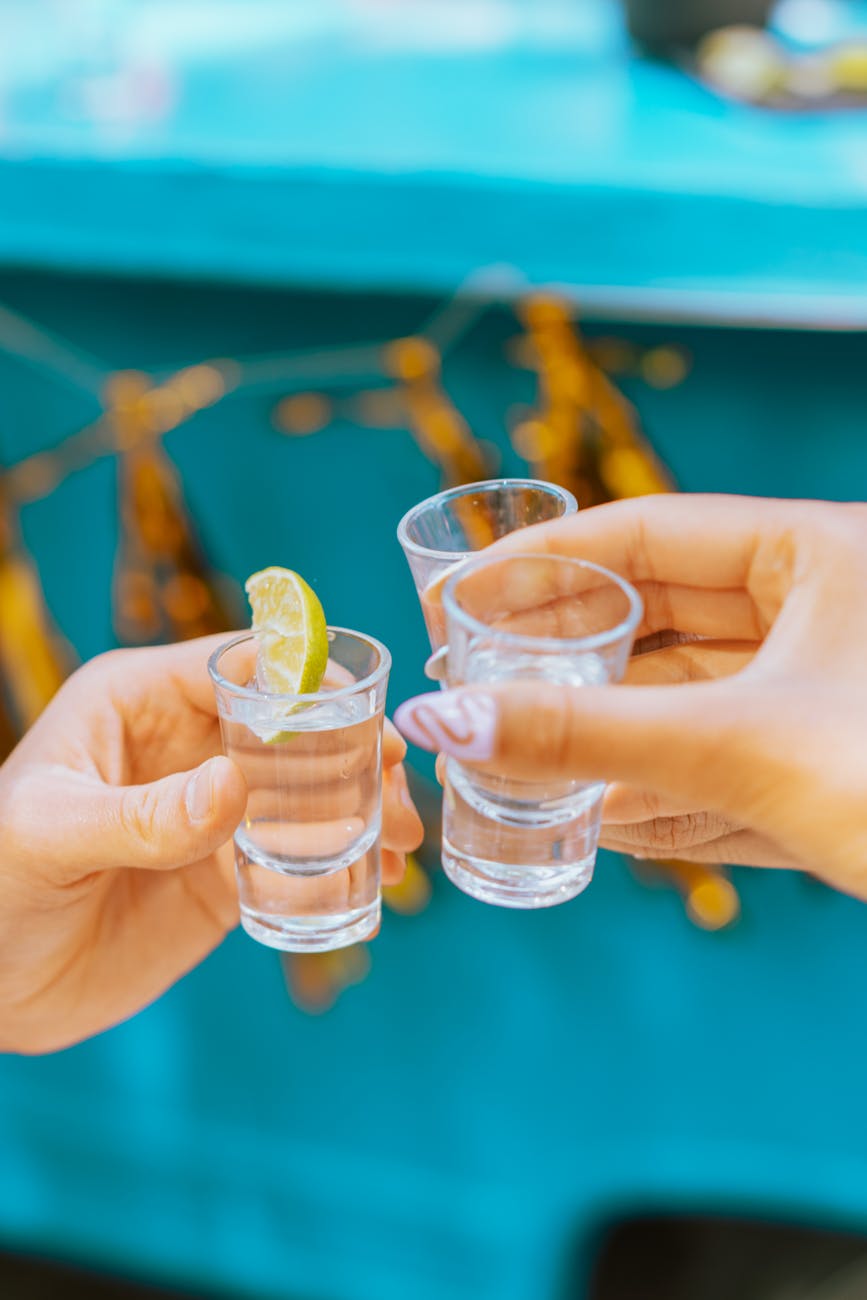 holding shot glasses with vodka